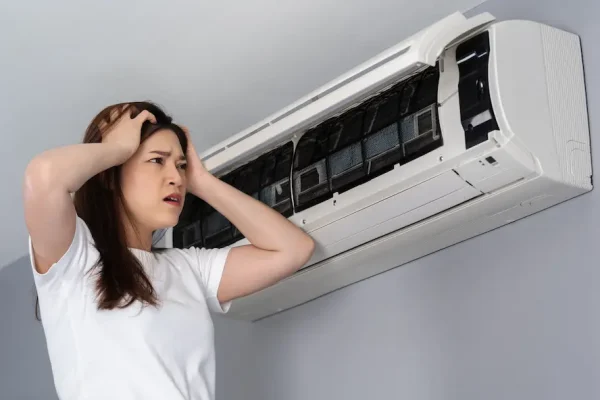 stressed-young-woman-has-problem-with-air-conditioner-home